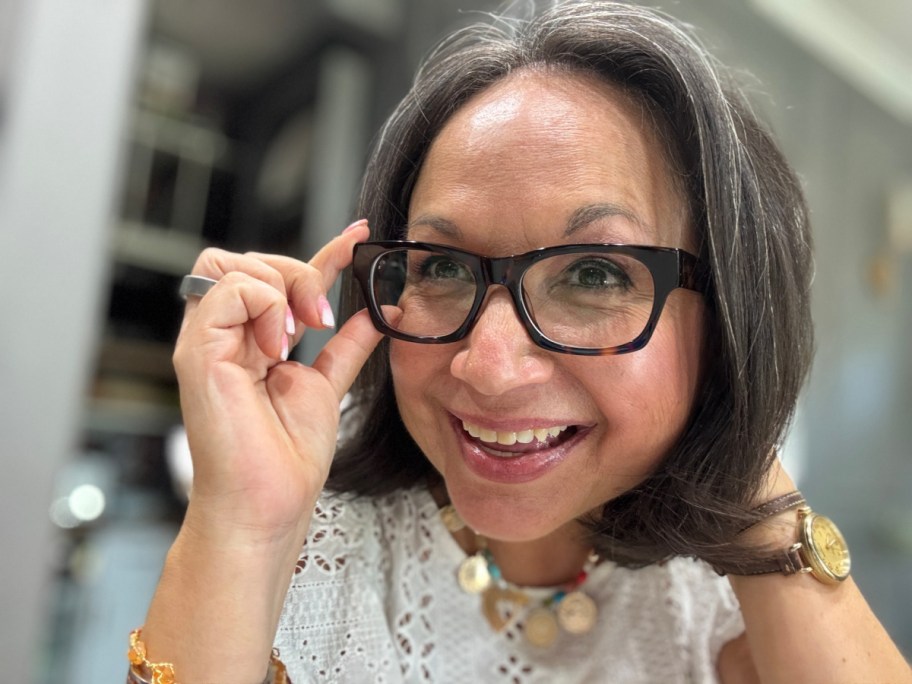 woman in brown glasses grabbing corner of frame
