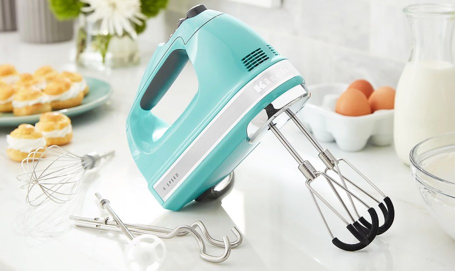 light blue hand mixer on counter with attachments