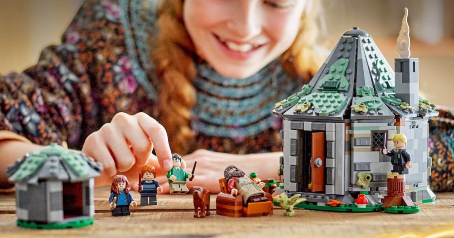 girl playing with LEGO Harry Potter Hagrid's Hut set