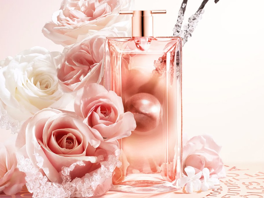 pink bottle of Lancome Idôle Aura Eau de Parfum with roses