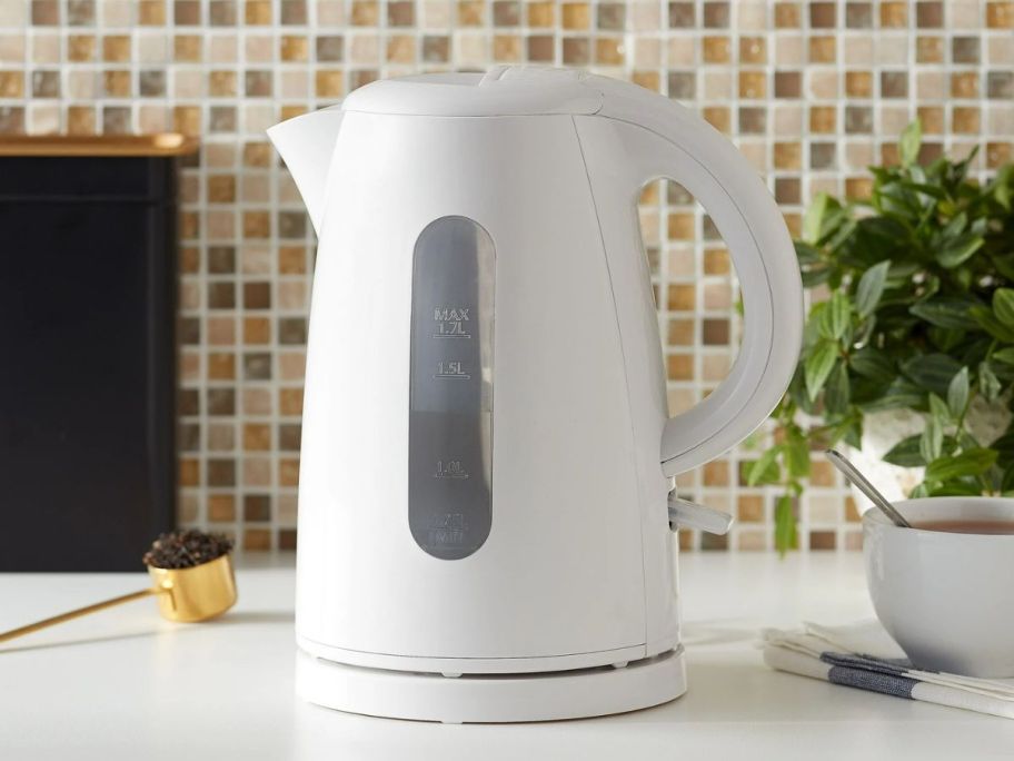 A white electric kettle on a counter