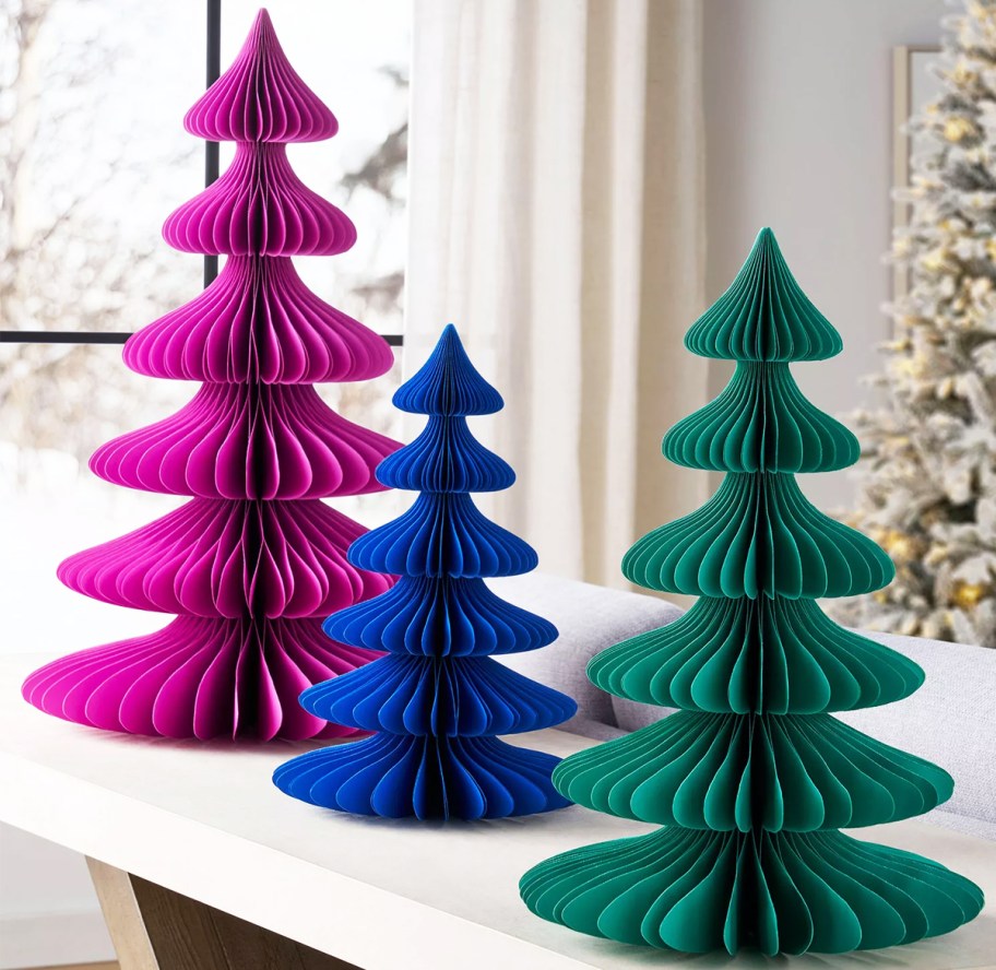 pink, dark blue, and teal paper christmas trees on table