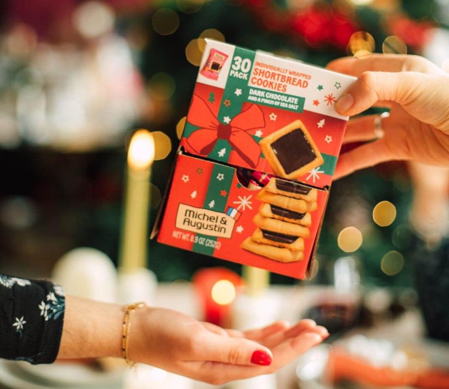 person handing someone a box of cookies