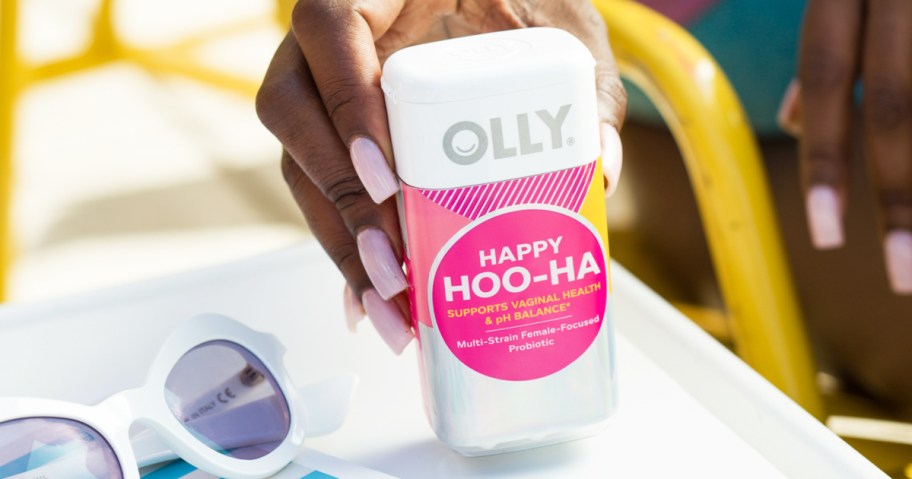 hand grabbing a bottle of OLLY Happy Hoo-Ha Capsules