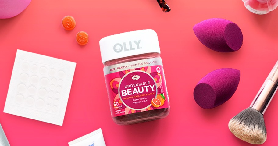 pink bottle of OLLY Undeniable Beauty Gummies near beauty products