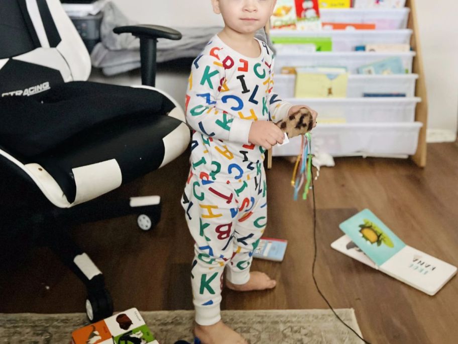 An adorable toddler playing in a room wearing Old Navy Alphabet Pajamas Toddler