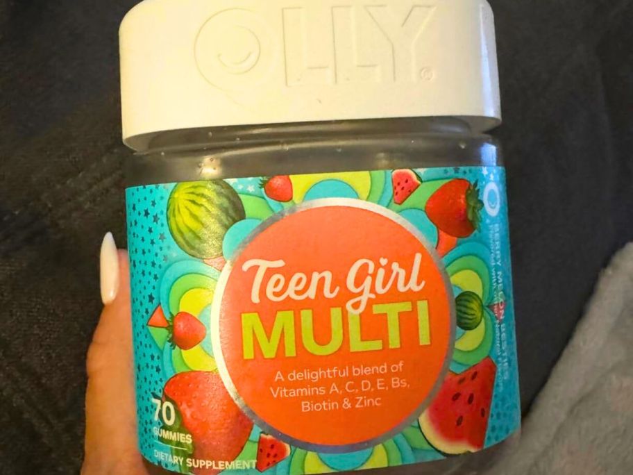 Hand holding a jar of Olly Teen Girl Gummy Multivitamins