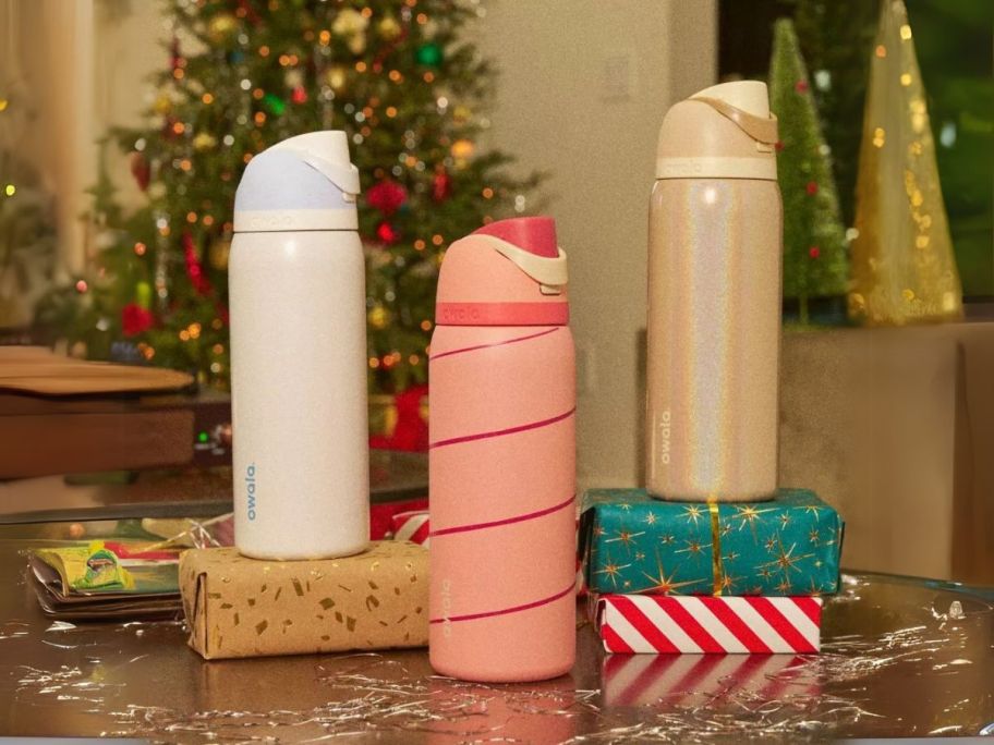 Owala Classy Christmas Water Bottles stacked on top of presents