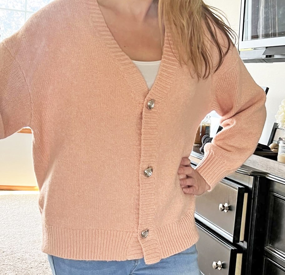 woman wearing a light pink cardigan with jeans