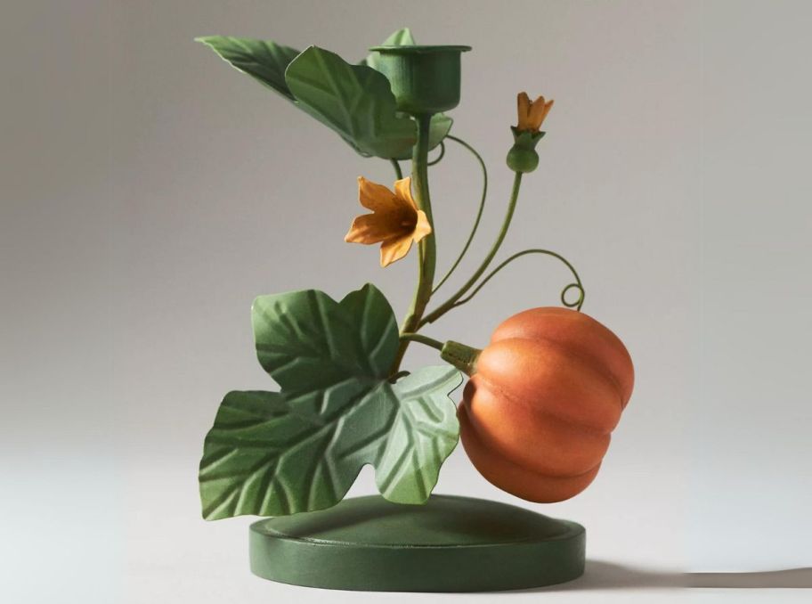  a green and orange metal pumpkin vie taper candle holder