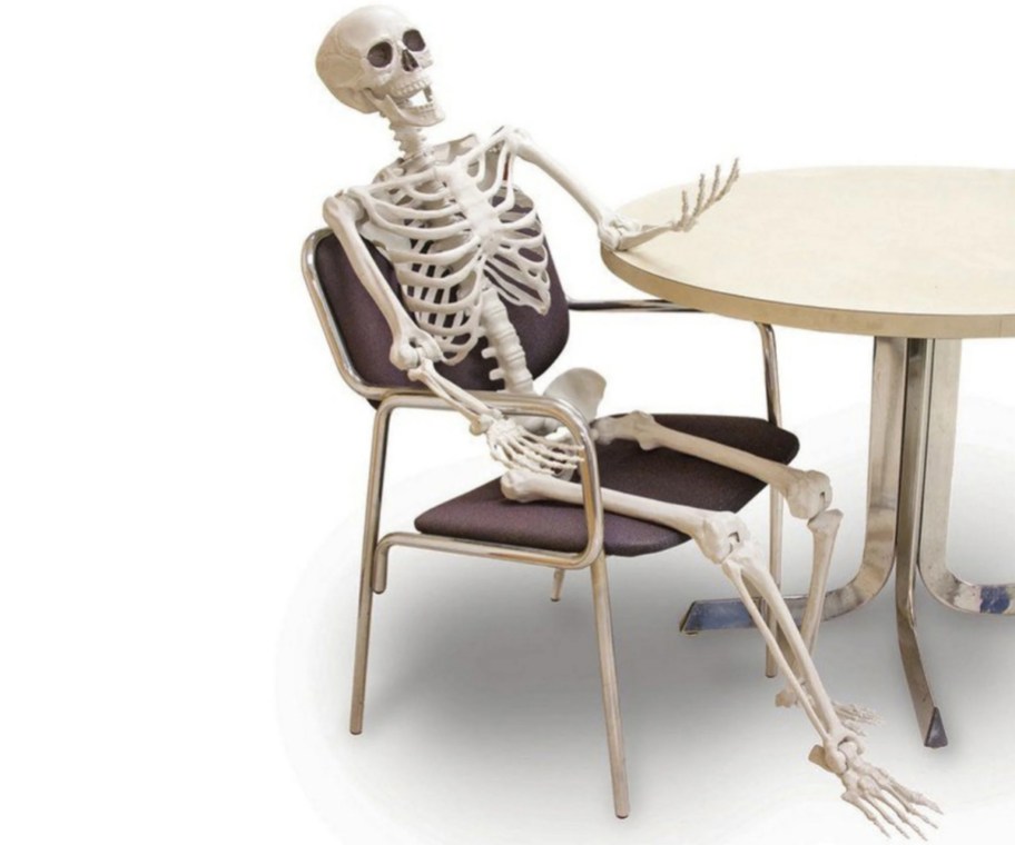5 ft skeleton sitting at a table