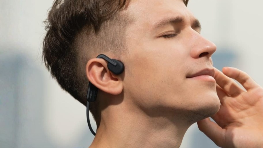 a man wearing a pair of open ear headphones