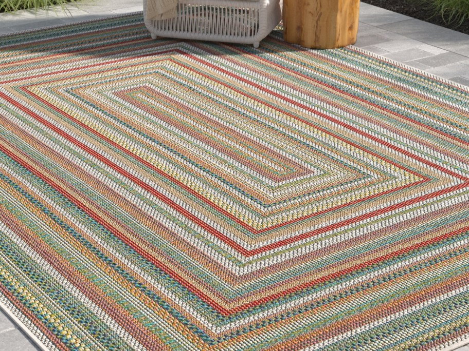 Sand & Stable Lucidia Multicolor Indoor_Outdoor 5x7 Area Rug with a chair on it