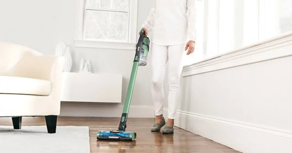 Woman cleaning with shark pet cordless stick vacuum cleaner