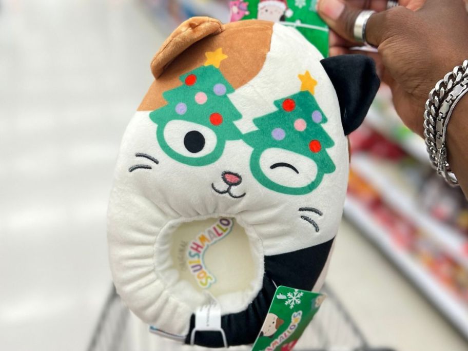 Hand holding a holiday cat squishmallow slipper