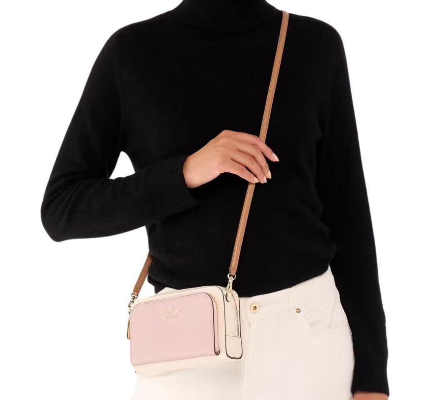 a woman wearing a small pink and white crossbody