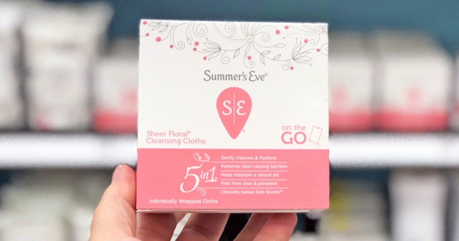 hand holding up a pink and white box of Summer's Eve Cleansing Cloths