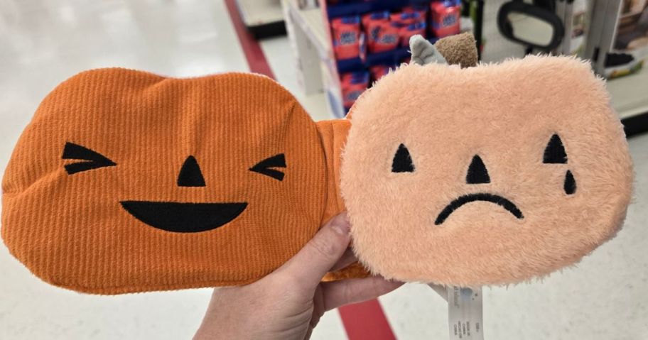 A person holding a plush pumpkin plush book