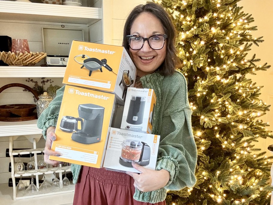 woman holding Toastmaster Kitchen Appliances boxes near christmas tree