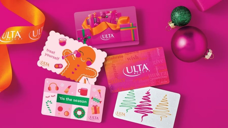 assorted ulta gift cards on a pink background surrounded by ribbon and Christmas ornaments