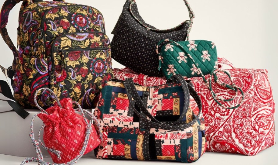 various Vera Bradley print bags, backpacks, and purses in reds, greens, and blacks