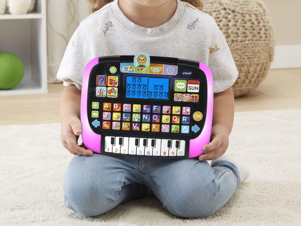 A child holding a VTech Little Apps Tablet