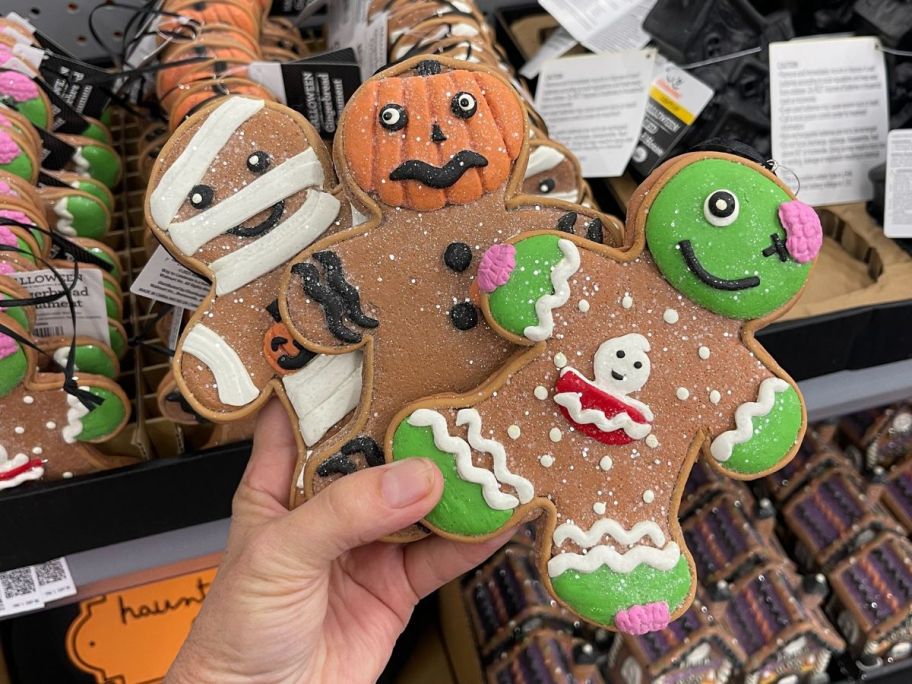 Hand holding 3 Halloween Gingerbread Cookie Decorations at Walmart.com