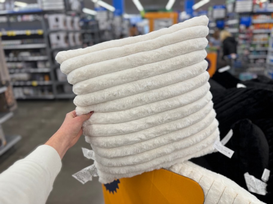 woman holding white mainstays throw pillow in walmart store