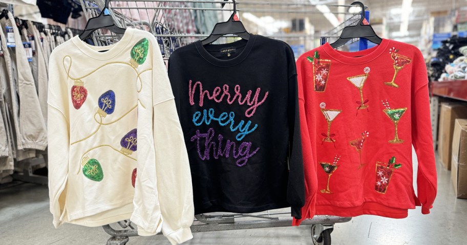 christmas sweaters hanging off shopping cart