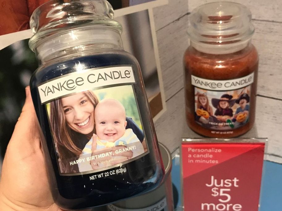 womans hand holding a personalized yankee jar candle