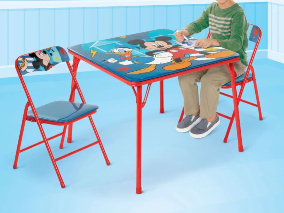 kid sitting at mickey mouse activity table