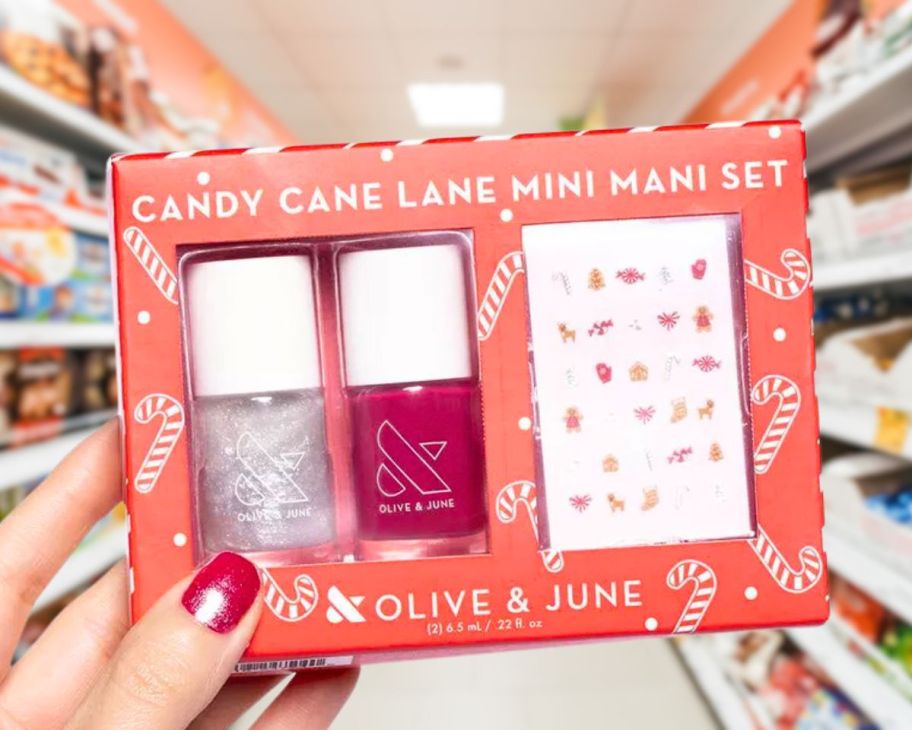 a womans hand holding a nail care gift set