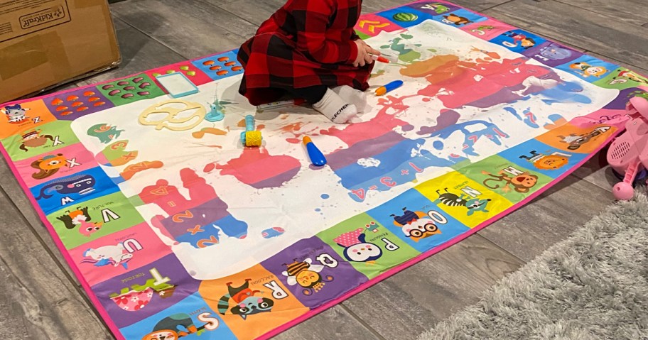 child playing on water doodle mat