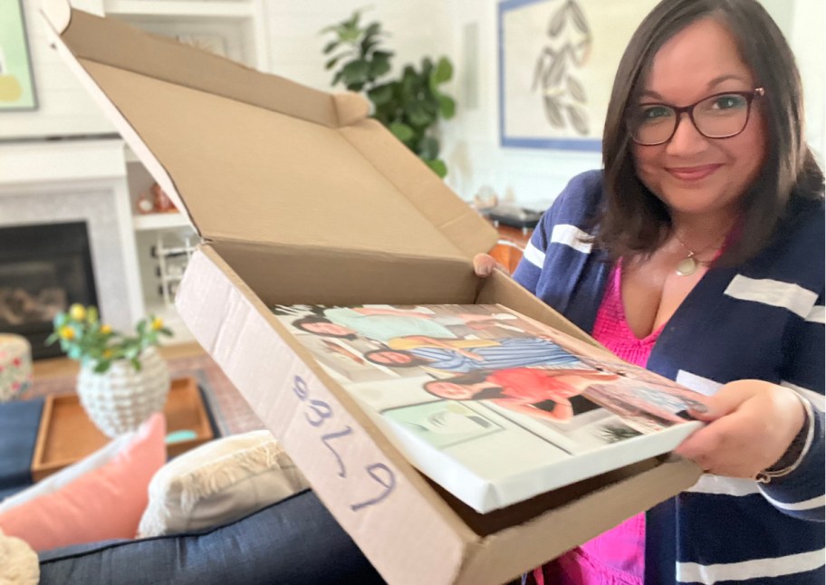 woman holding up box with canvas in it