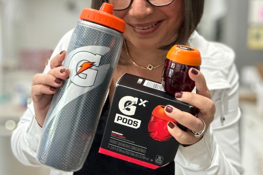 A woman holding a Gatorade bottle and a pod