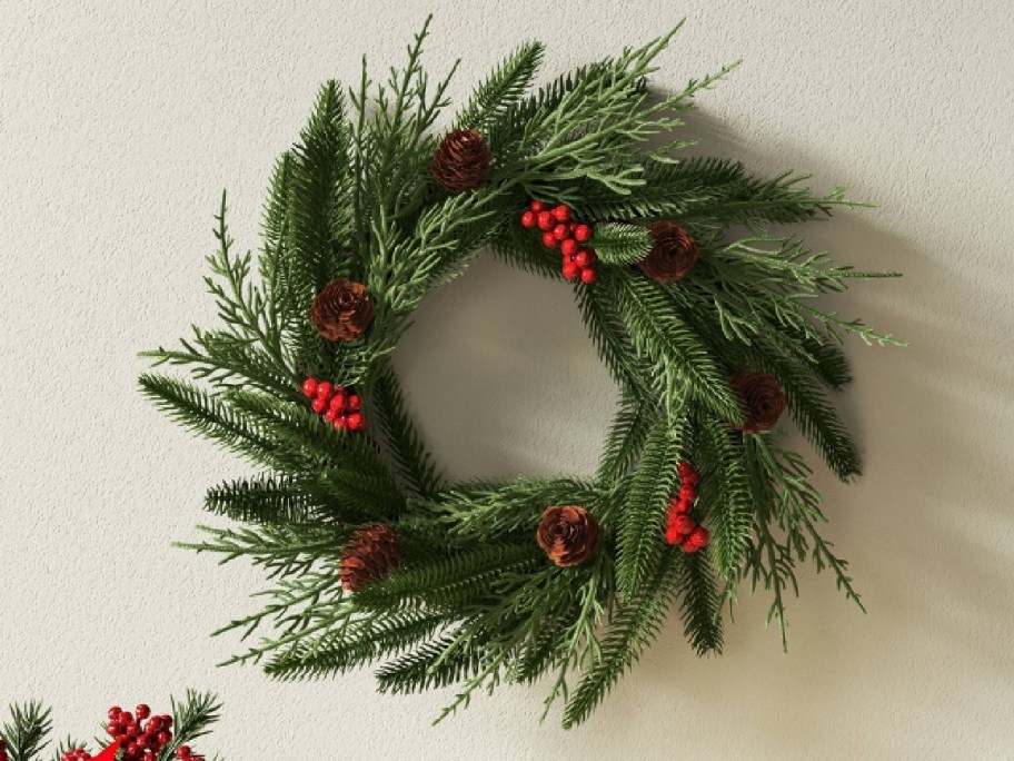 green wreath with berries displayed a back drop