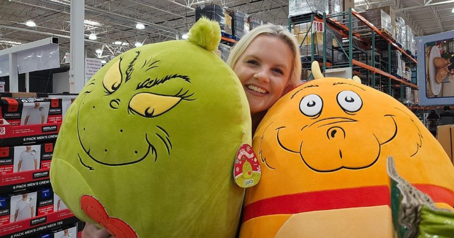woman holding grinch and max squishmallows in store