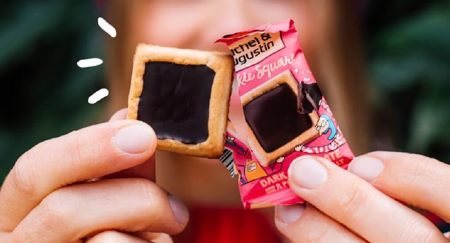 hand holding square chocolate cookies with wrapper next to it