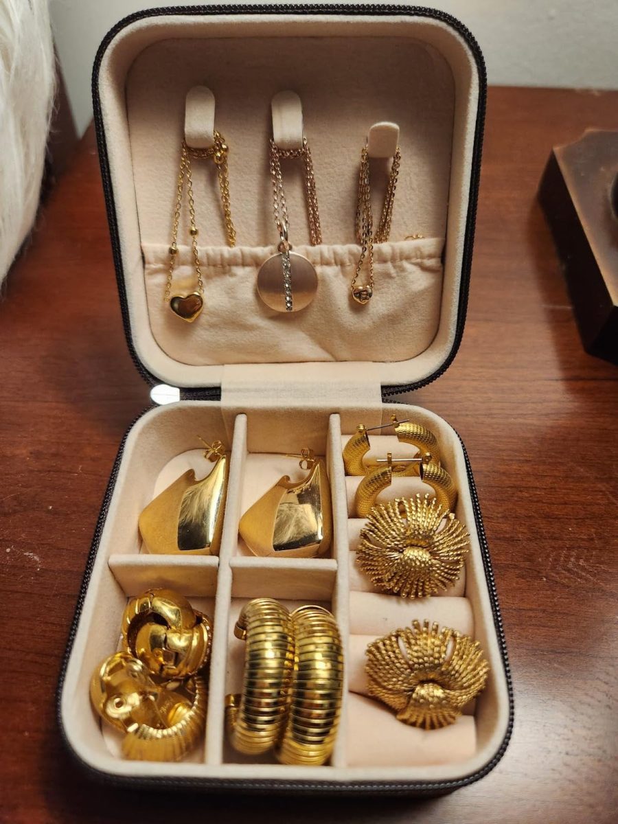 open travel jewelry case with gold earrings and necklaces inside