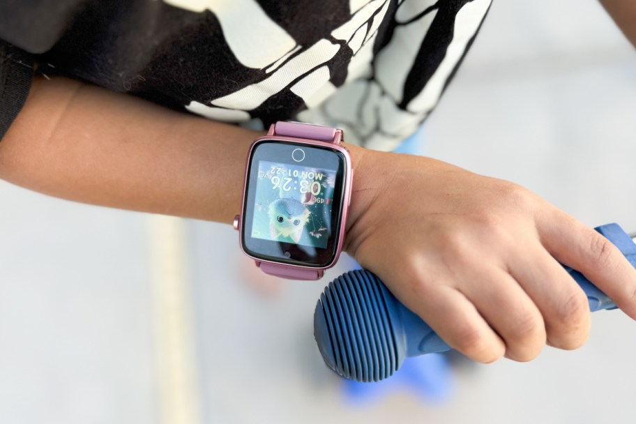 kids hand on scooter wearing smartwatch