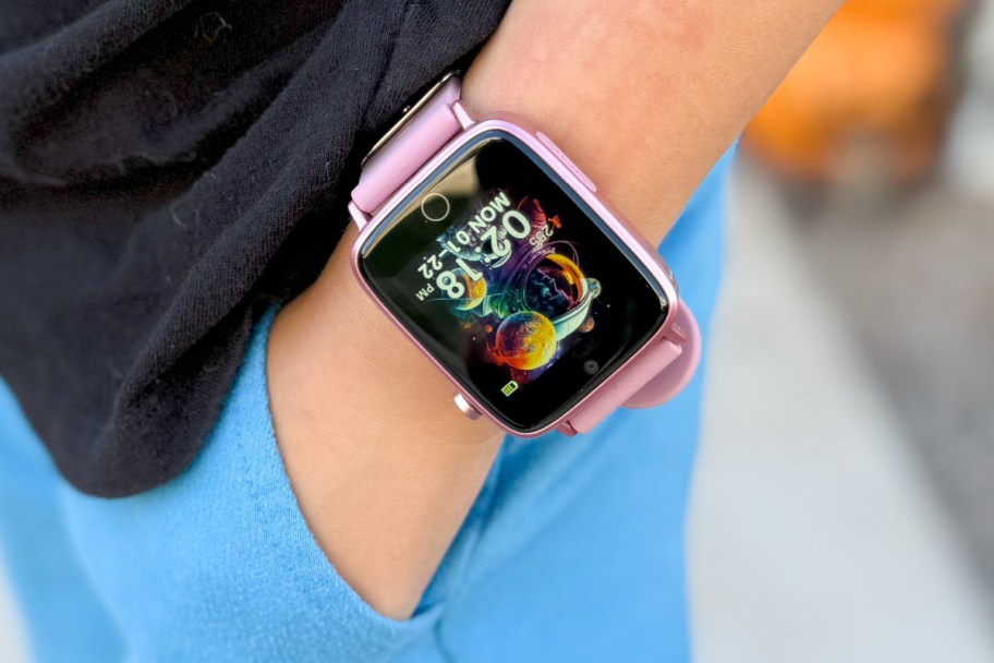 kids hand in pocket wearing pink smartwatch