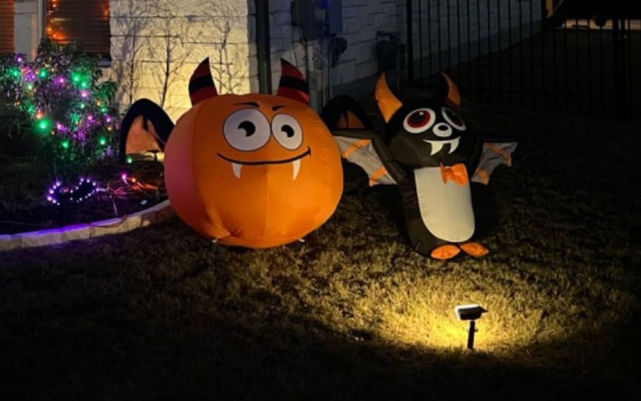 outdoor led solar light shining on two halloween decorations