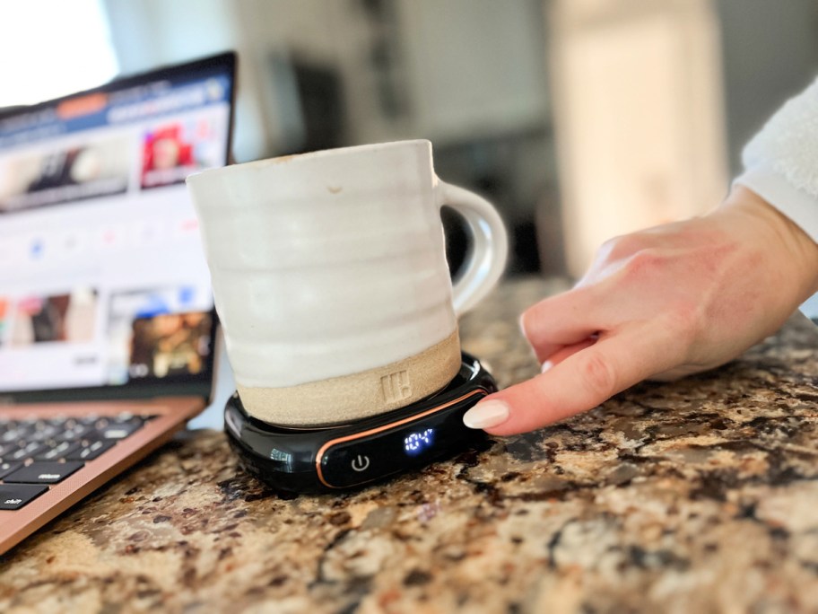 woman pushing a button on a lerat coffee warmer