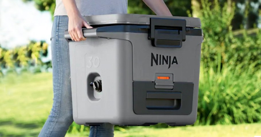 person holding gray ninja cooler 