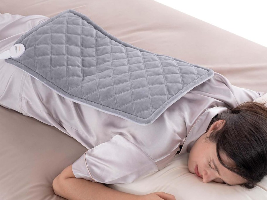 Woman laying down with heating pad