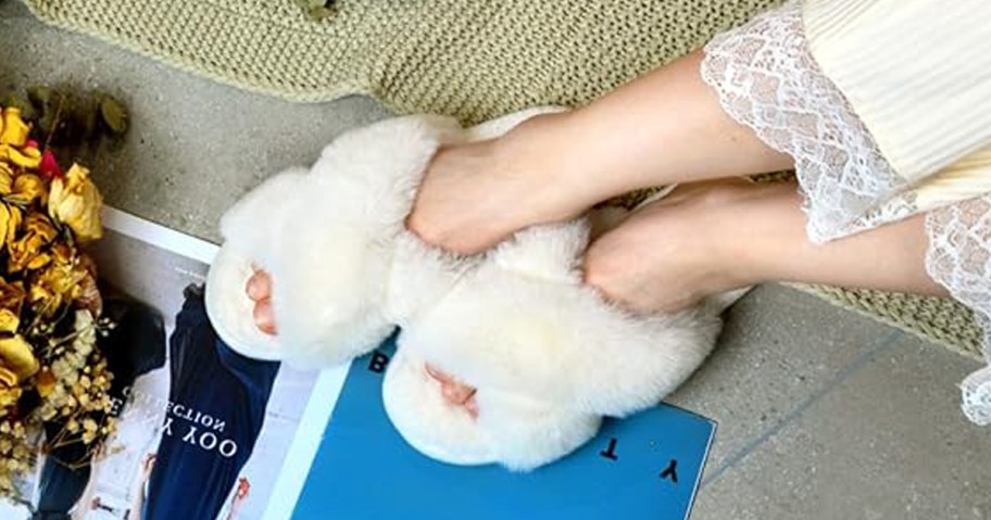 woman's feet wearing parlovable white slippers while sitting on the floor