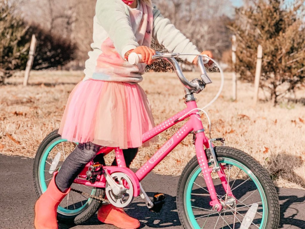 little girl in tutu riding pink guardian bike