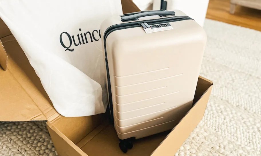 quince luggage in box on floor