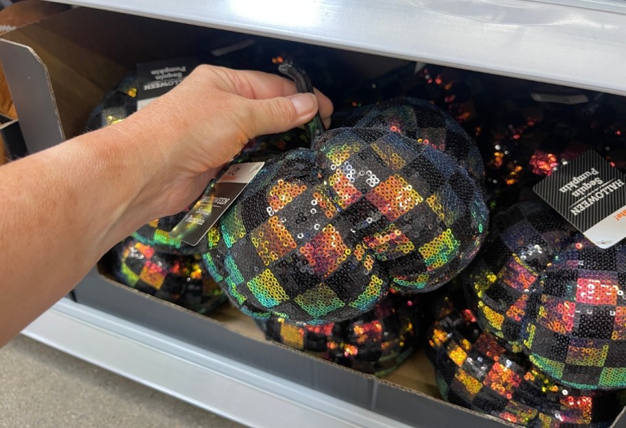 womans hand holding a sequined pumpkin
