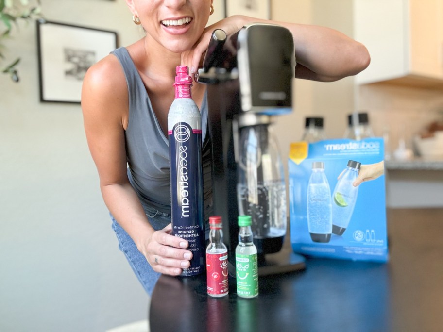 woman posing behind a sodastream art bundle